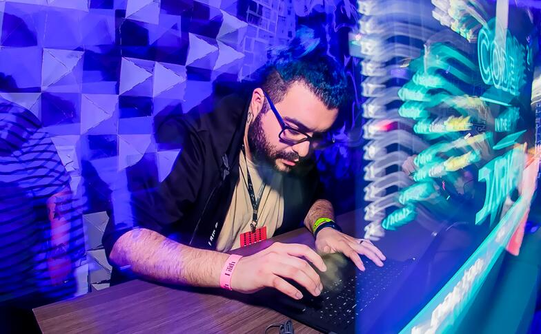 Foto do Vitor Norton, homem branco alto, cabelo comprido e azul